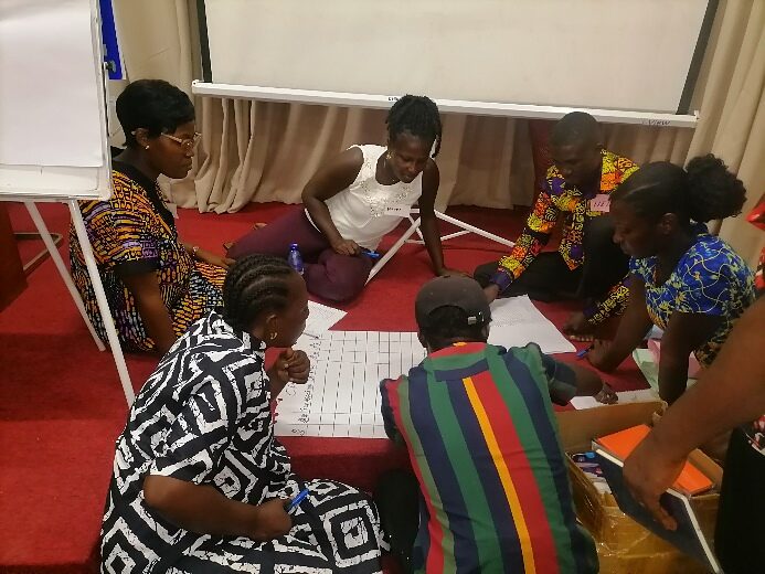 Participants co-creating solutions around a shared worksheet