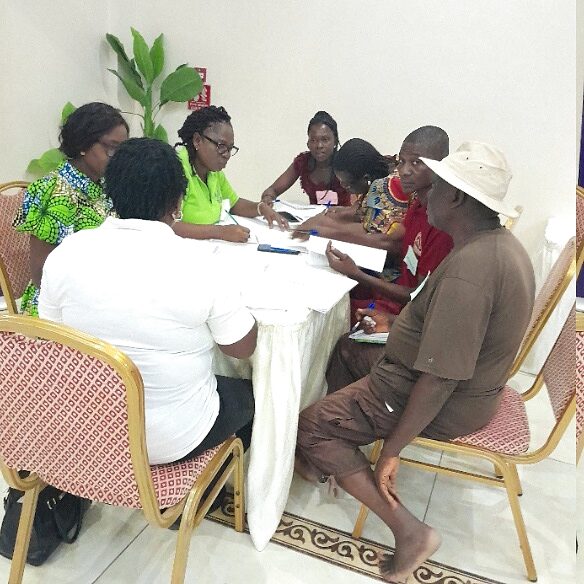 Small focus group gathered around a table sharing lived experience