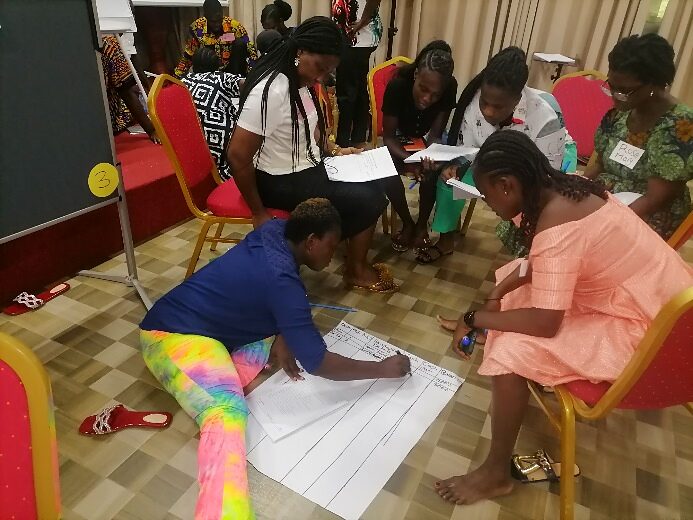 Participants mapping local assets on paper spread across the floor