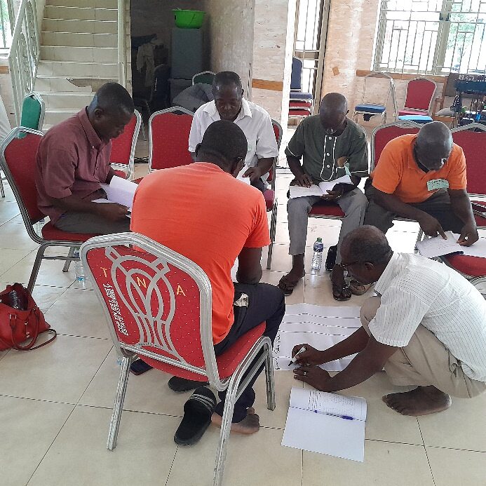 Group of participants gathered on the floor solving a written challenge together