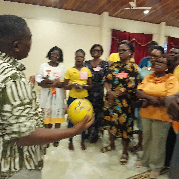 Facilitator running an energiser with a ball during a team building session