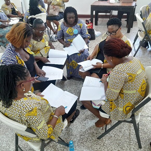 Participants seated in a circle reviewing training handouts together